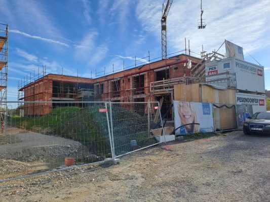 Foto eines im Bau befindlichen Gebäudes. Man sieht den Rohziegelbau und das Baugerüst.